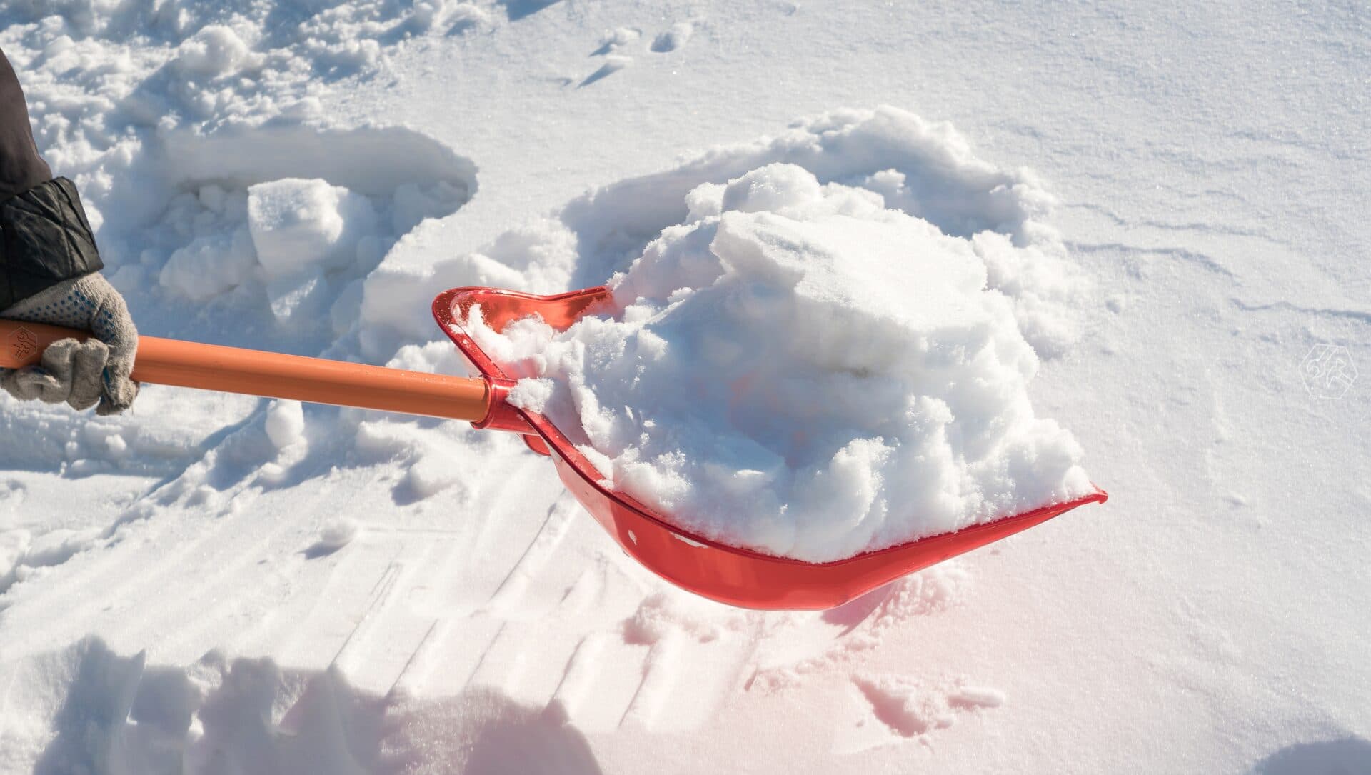 Rote Schneeschaufel räumt frischen Schnee